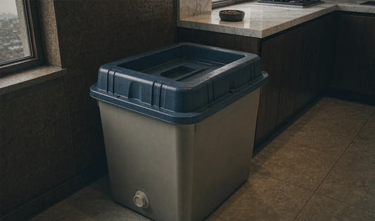 A rigid lidded pet food container on a concrete floor in an outbuilding